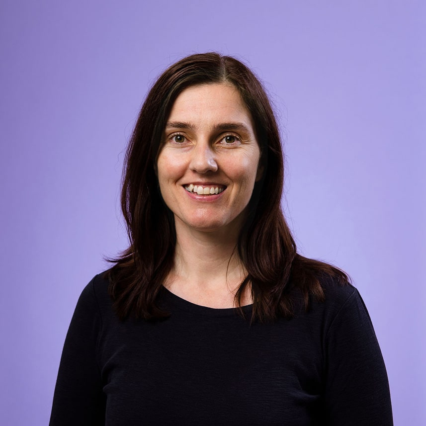 Carly Moorfield, miniý Support Liaison, smiling at the camera against a purple background